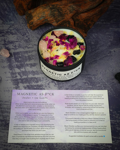 Magnetic As F*ck candle with obsidian and rose quartz crystals shown on a textured surface alongside its product info card.