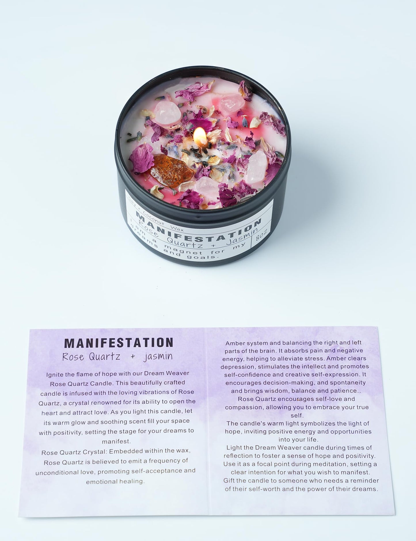 Manifestation candle with rose petals and crystals in a black tin, placed on a white background, shown with an informational card describing the rose quartz and jasmin candle meaning.