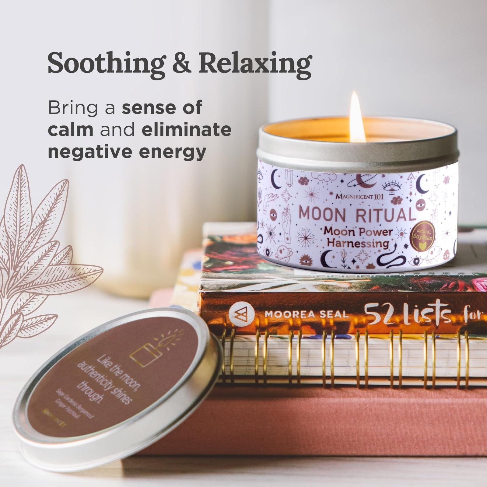 Moon Ritual scented candle burning in a decorative tin, placed on stacked books with text promoting soothing and relaxing benefits on a soft, neutral background.