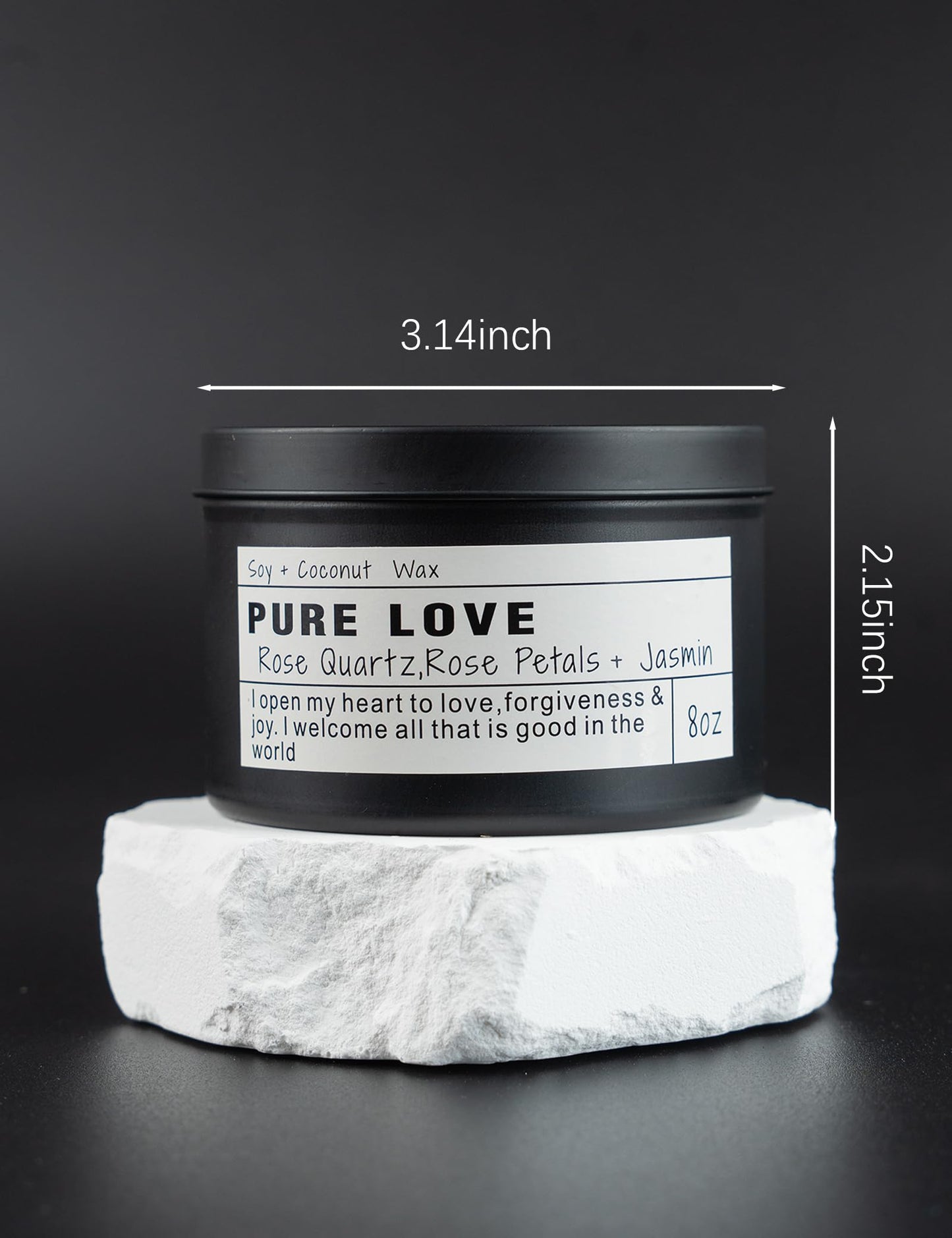 Pure Love soy and coconut wax candle in a black jar displayed on a white stone base, showing product dimensions of 3.14 inches wide and 2.15 inches tall against a dark background.