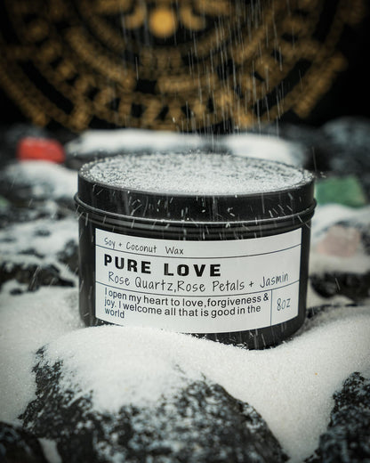 Pure Love candle with rose quartz and rose petals displayed on a snowy surface with falling snow.